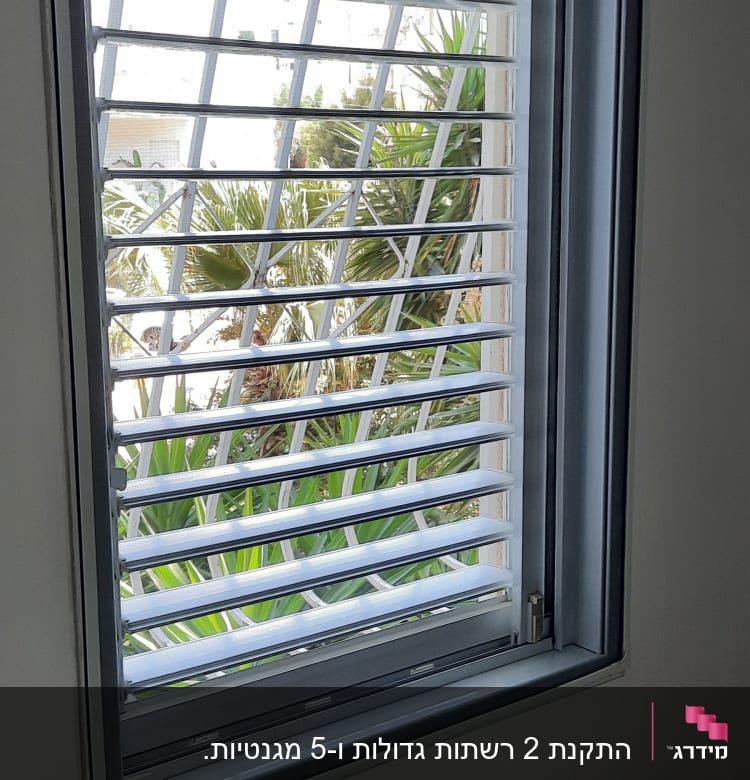 חלון עם תריסי אלומיניום פתוחים